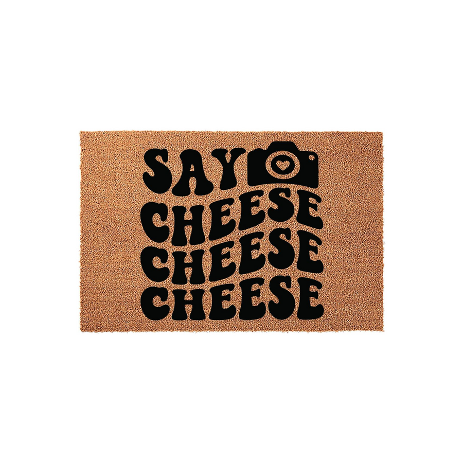 Say Cheese Photography Coir Doormat featuring a fun, wavy black font and a camera icon on a natural tan fiber background, making it a creative and welcoming entrance mat for any home or photography studio entryway.