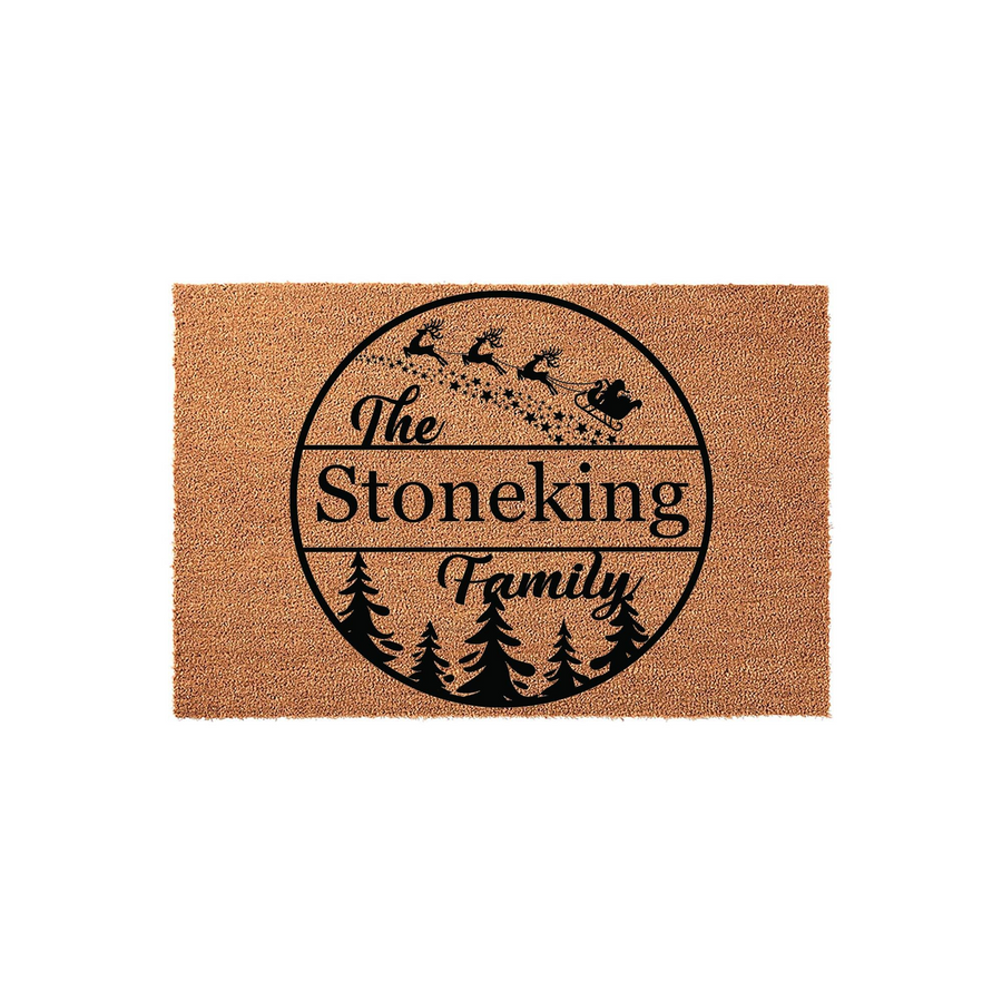 Personalized Christmas family name doormat featuring a circular design with a silhouette of Santa and his reindeer flying over a forest of pine trees, printed on a natural coir fiber mat against a clean white studio background.