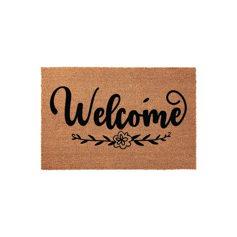 Welcome coir doormat featuring a natural tan fiber texture and bold black script lettering, accented by a simple floral and leaf design centered below the text for a classic farmhouse entryway look on a clean white background.