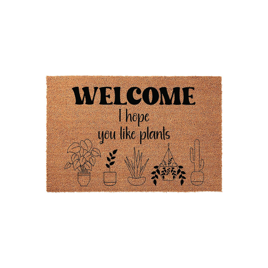I hope you like plants welcome doormat made of natural coir fiber, featuring a playful black printed message and a series of cute potted plant illustrations including a hanging planter and a cactus on a clean white studio