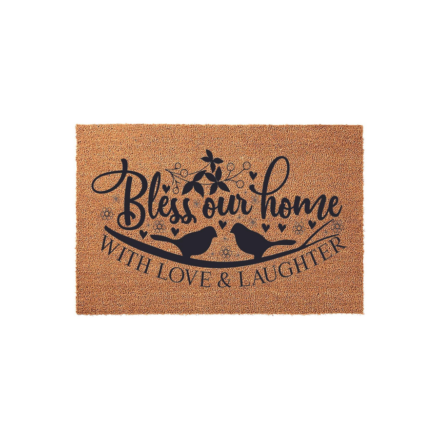 Bless Our Home Coir Doormat featuring a charming design of two birds perched on a branch with floral accents and hearts, printed in black ink on a natural brown textured fiber surface for a welcoming front porch entryway decor.