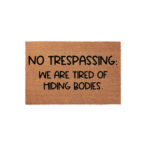 Funny No Trespassing Doormat featuring a natural coir texture and bold black text that reads, No Trespassing: We Are Tired Of Hiding Bodies, making it a humorous and durable outdoor welcome mat for your front porch or entryway