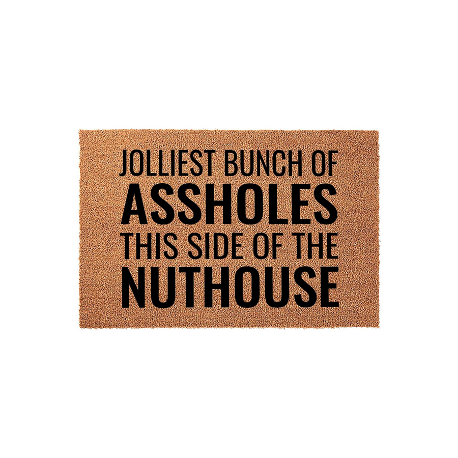 Funny Holiday Doormat featuring the text Jolliest Bunch of Assholes This Side of the Nuthouse printed in bold black lettering on a natural brown coir fiber mat, perfect for adding a humorous touch to your front porch decor this