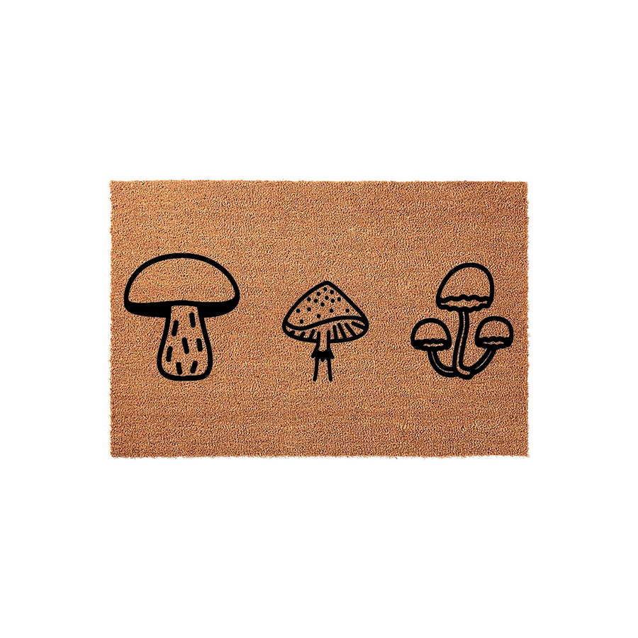 Mushroom nature doormat featuring a trio of black line art fungi illustrations printed on a textured natural coir fiber mat, creating a charming woodland aesthetic for a front porch or entryway floor decor in a clean studio