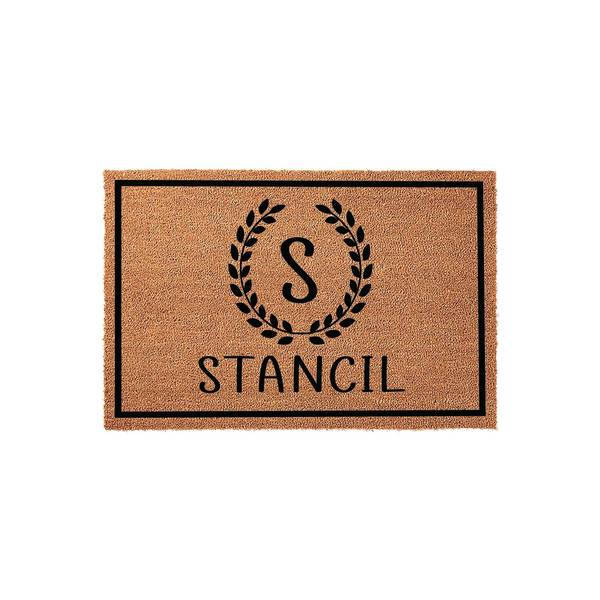 Personalized coir doormat featuring a black border, a central laurel wreath monogram with the letter S, and a custom family name printed in a clean font on a natural tan fiber background for a classic front porch entryway decor.