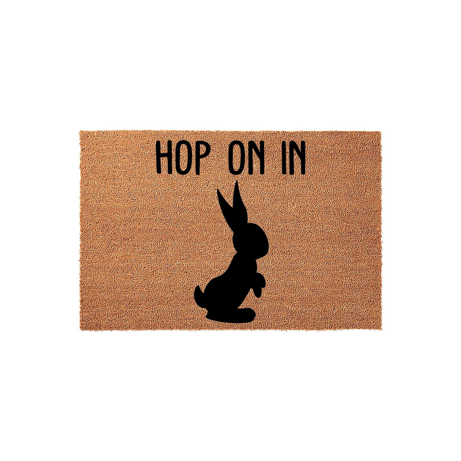 Hop On In Easter Bunny Coir Doormat featuring a natural brown fiber texture with a bold black silhouette of a rabbit and the playful text Hop On In printed above, creating a festive spring welcome for your front porch entryway.