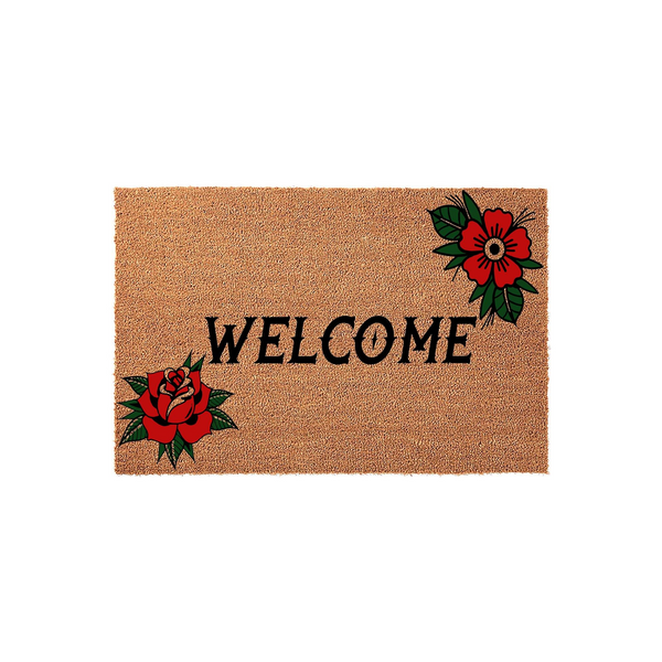 Traditional tattoo style floral welcome doormat featuring a natural coir texture, bold black lettering, and vibrant red rose illustrations in opposite corners to create a classic, artistic entryway look for your home front porch