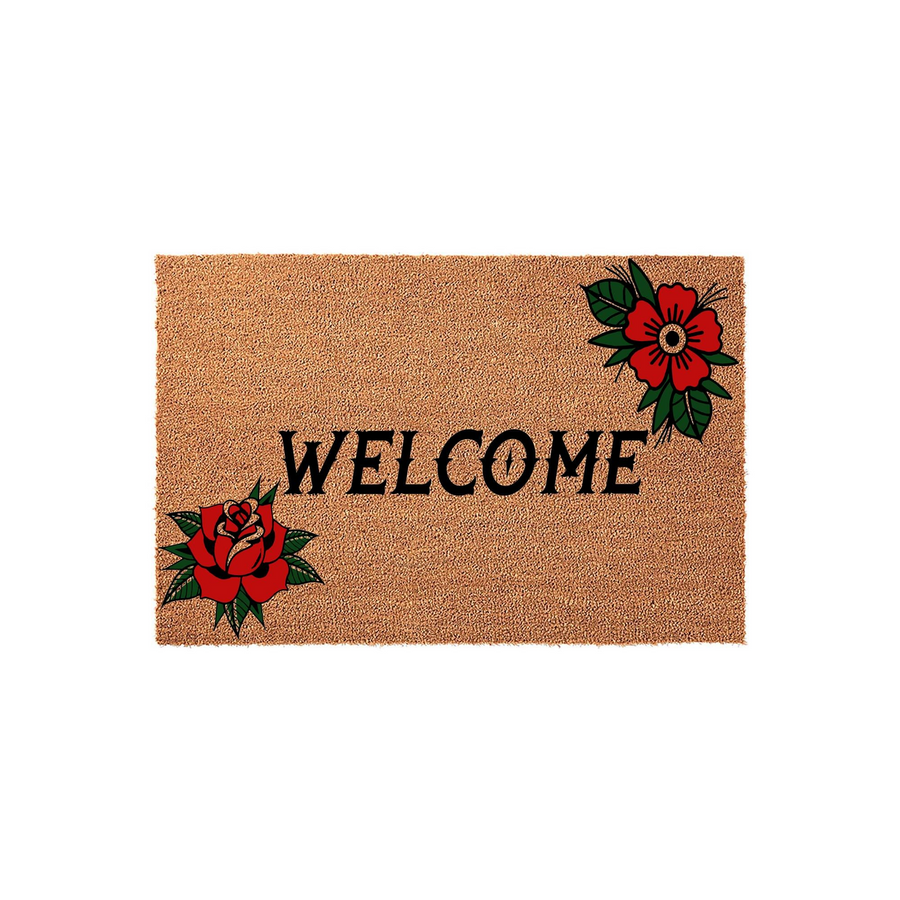 Traditional tattoo style floral welcome doormat featuring a natural coir texture, bold black lettering, and vibrant red rose illustrations in opposite corners to create a classic, artistic entryway look for your home front porch