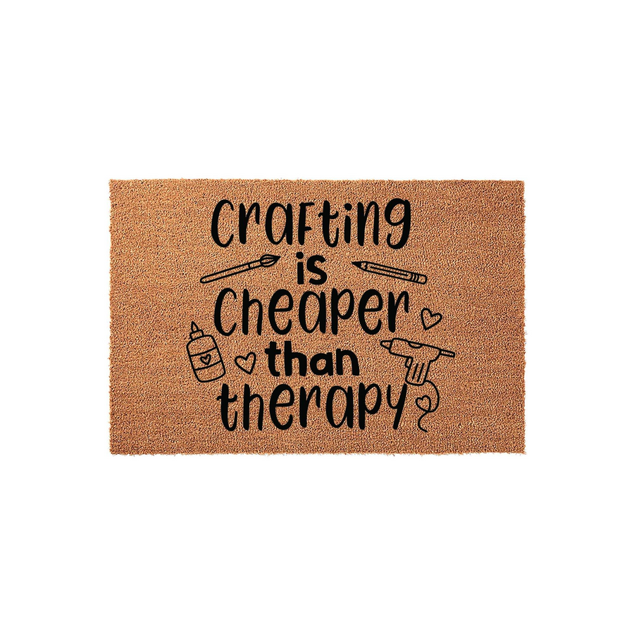 Crafting Is Cheaper Than Therapy coir doormat featuring black text and cute illustrations of a paintbrush, pencil, glue bottle, and hot glue gun on a natural brown fiber background, perfect for a creative person's home entryway