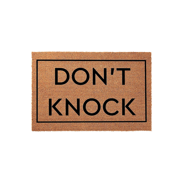 Don't Knock Coir Doormat featuring a natural tan fiber texture with a bold black border and the text Don't Knock printed in the center, providing a humorous and functional welcome mat for your front porch or entryway decor.