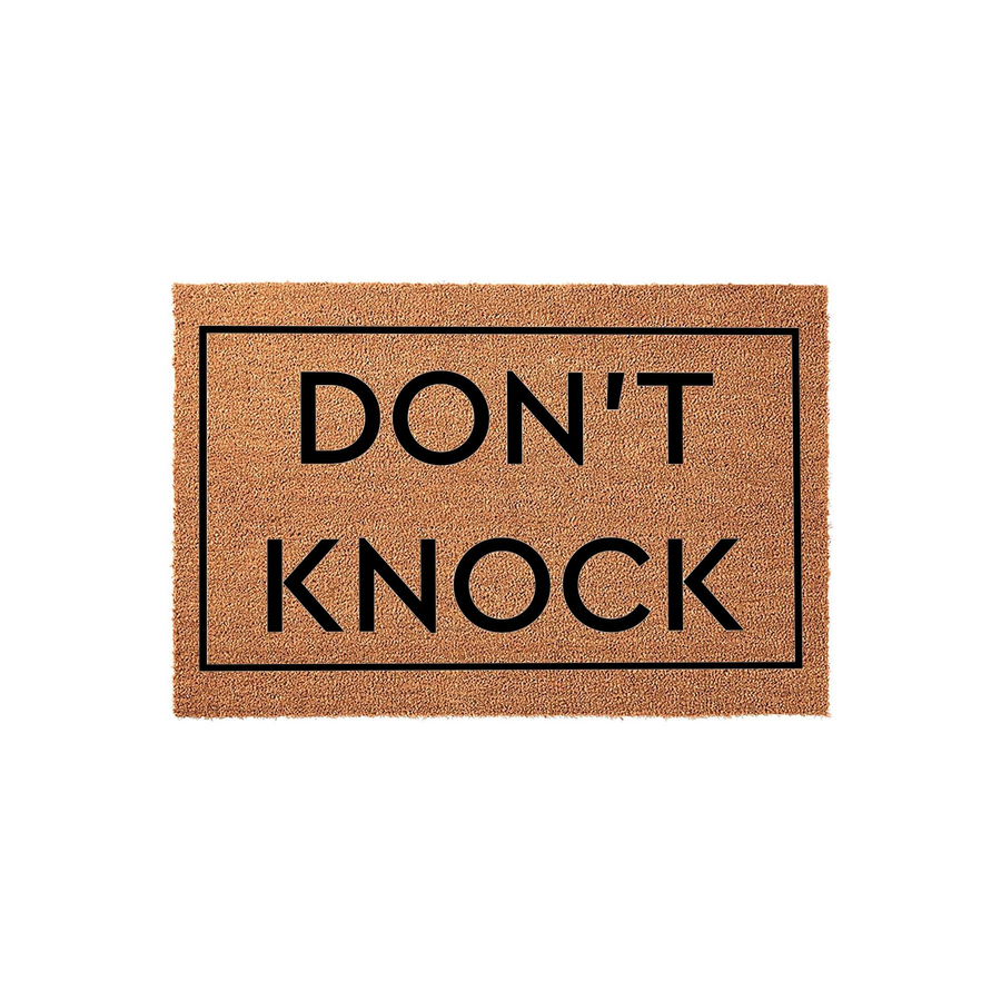Don't Knock Coir Doormat featuring a natural tan fiber texture with a bold black border and the text Don't Knock printed in the center, providing a humorous and functional welcome mat for your front porch or entryway decor.