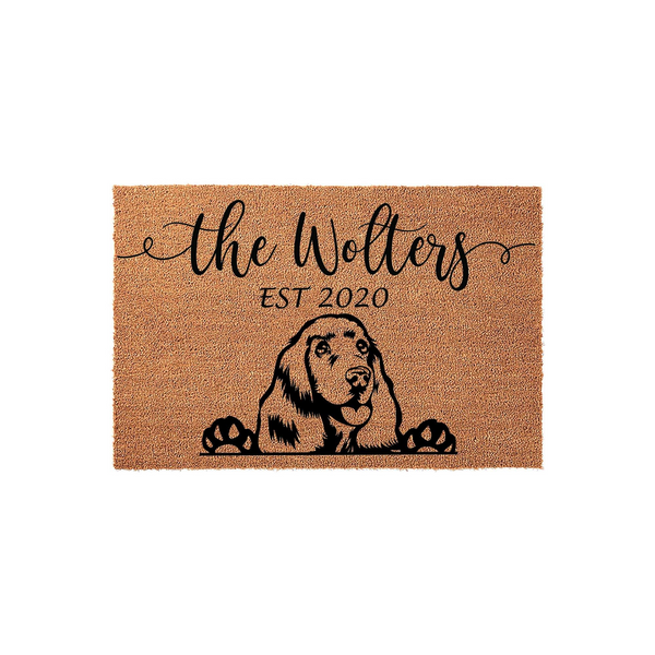 Personalized Cocker Spaniel doormat featuring a natural coir texture with a black printed illustration of a dog peeking over its paws, customized with a family name and established year for a welcoming front porch entrance decor.