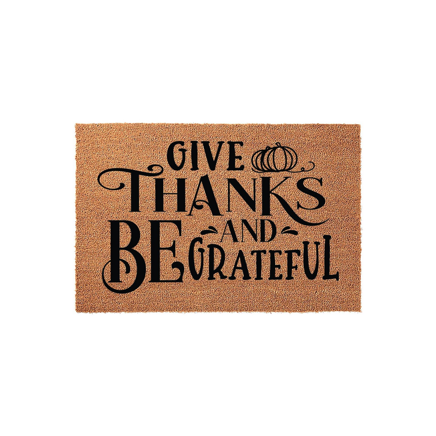 Give Thanks and Be Grateful fall doormat made of natural coir fiber, featuring black decorative typography and a small pumpkin icon on a plain white background for a festive autumn entryway decor look.