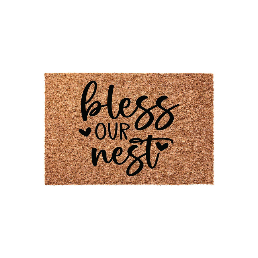 Bless Our Nest Coir Doormat featuring a natural brown fiber texture and bold black script lettering, creating a welcoming farmhouse aesthetic for your front porch entrance that adds a touch of warmth to any home entryway decor.