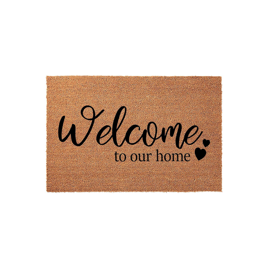 Welcome to our home coir doormat featuring a natural tan fiber texture and bold black script lettering, accented with small decorative hearts to create a warm and inviting entrance for your front porch or entryway decor.