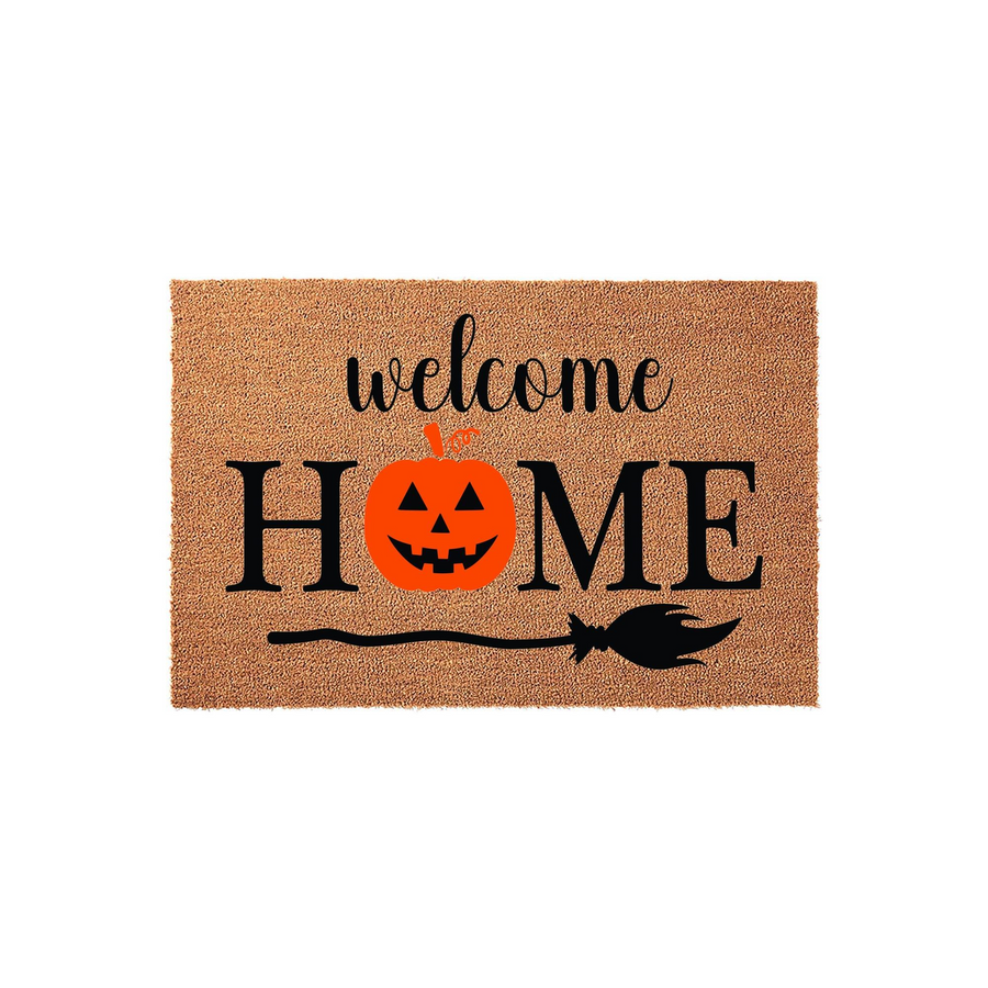 Halloween Welcome Home doormat featuring a textured coir surface with black lettering, a bright orange jack-o-lantern pumpkin replacing the letter O, and a black witch broom graphic underneath for a festive seasonal porch