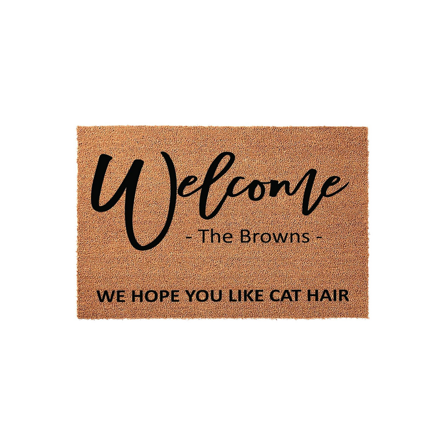 Personalized Cat Lover Coir Doormat featuring the word Welcome in script, a custom family name, and the humorous phrase We Hope You Like Cat Hair printed in bold black text on a natural brown textured fiber background.