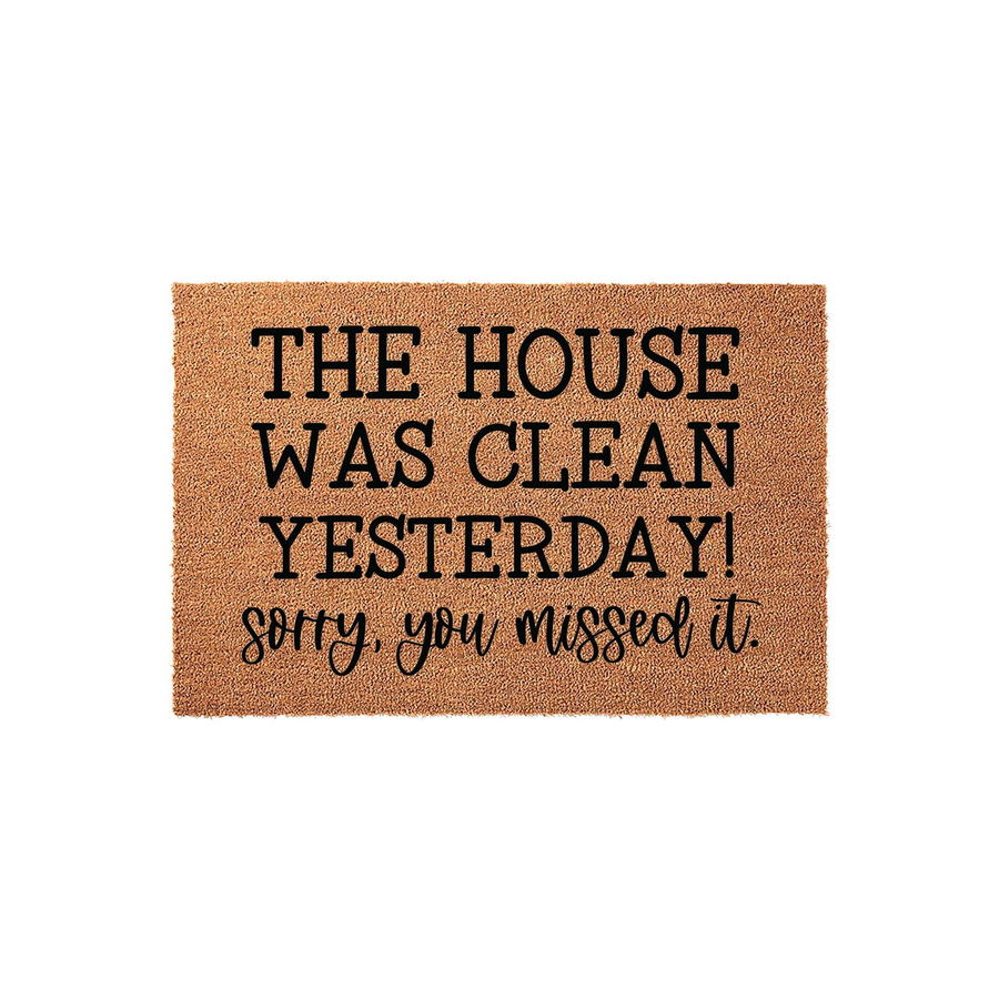 Funny doormat with the text The house was clean yesterday sorry you missed it printed in black on a natural coir fiber background, featuring a mix of bold block lettering and a playful script font for a welcoming front porch