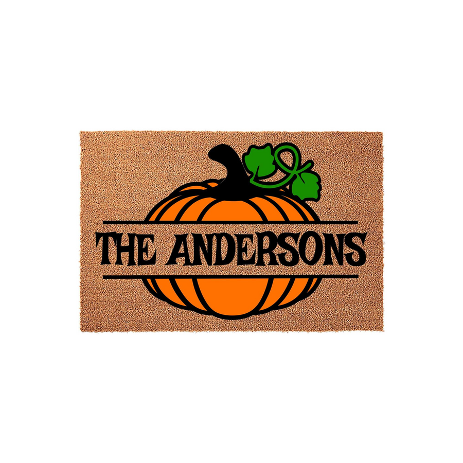 Personalized pumpkin fall doormat featuring a bright orange pumpkin graphic with a green vine and a black horizontal banner across the center for a custom family name, set against a natural tan coir fiber background for autumn