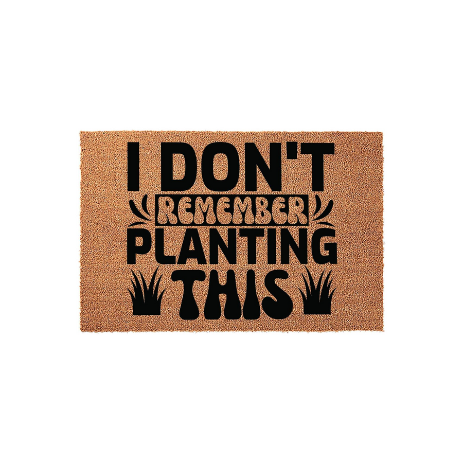 Funny Garden Doormat with the text I Don't Remember Planting This printed in bold black lettering on a natural tan coir fiber background, featuring decorative grass icons that add a playful touch to this outdoor home entryway