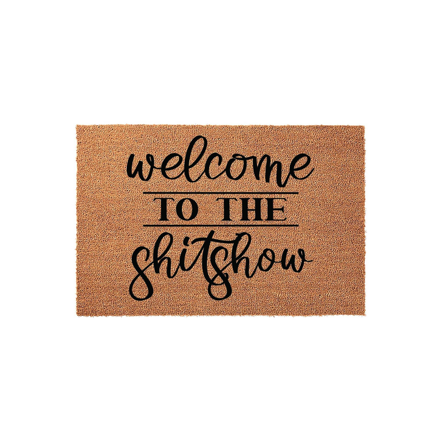 Funny Welcome To The Shitshow doormat made of natural coir fiber with a rustic texture, featuring bold black script and block lettering centered on a plain white background for a humorous home entryway decor statement.