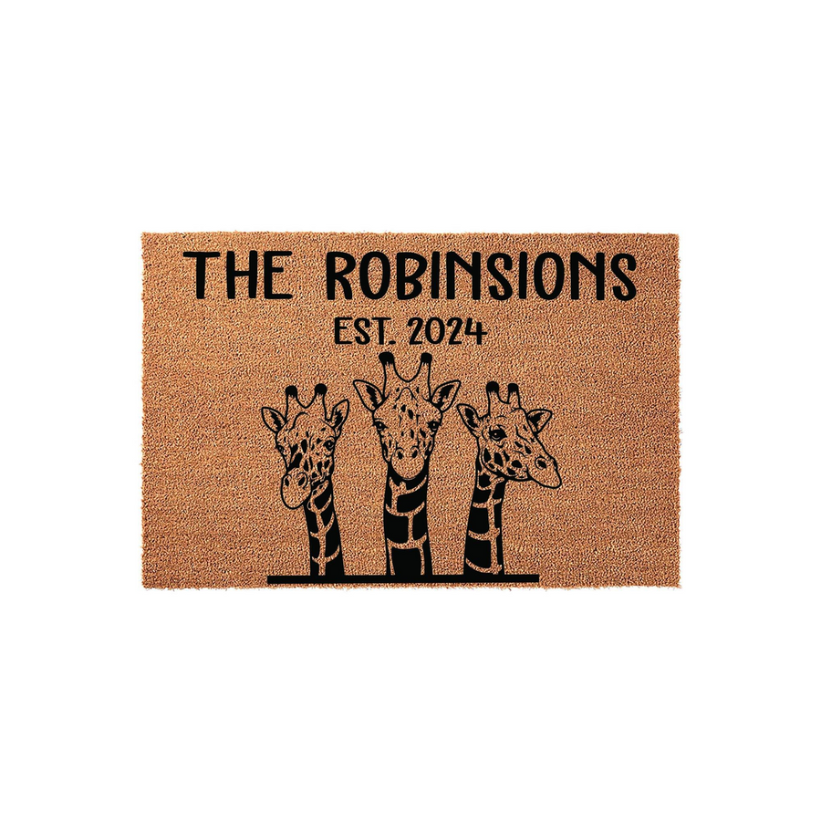 Personalized Giraffe Family Doormat featuring three illustrated giraffes peeking over a line, with custom family name text and established year printed on a natural tan coir fiber mat against a clean white studio background.