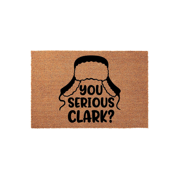 Funny Christmas doormat featuring a black graphic of a winter trapper hat and the text You Serious Clark, printed on a natural tan coir fiber mat that adds a festive and humorous touch to your holiday home entryway decor.