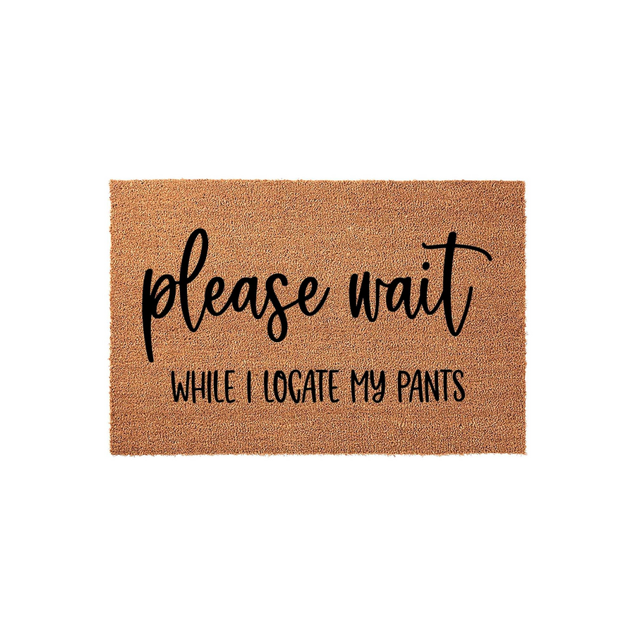 Funny Please Wait While I Locate My Pants doormat featuring bold black text printed on a natural brown coir fiber mat, creating a humorous and welcoming entrance decor piece for your home front porch or entryway floor.