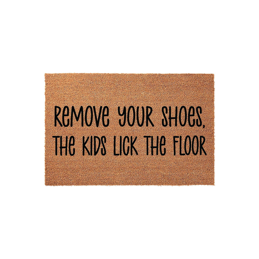 Funny Remove Your Shoes The Kids Lick The Floor coir doormat featuring bold black lettering on a natural brown fiber background, providing a humorous and practical welcome for any home entryway or front porch decor setting.