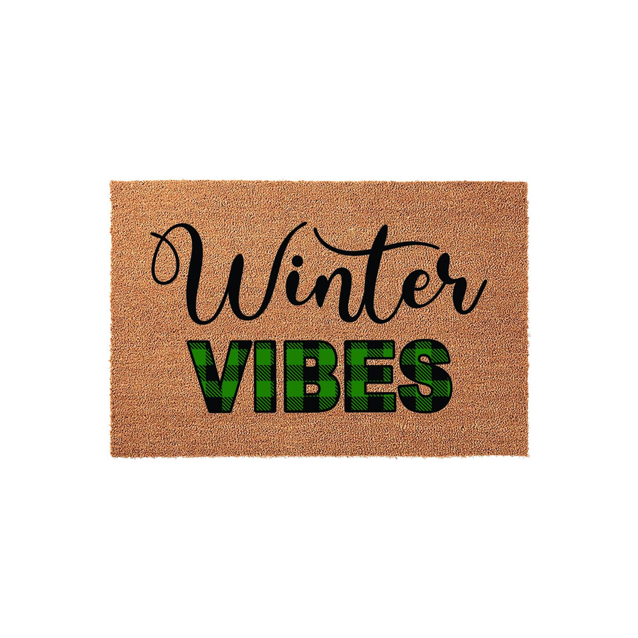 Winter Vibes coir doormat featuring a natural brown fiber texture with the word Winter in elegant black script and the word VIBES in bold green and black buffalo plaid lettering for a festive seasonal front porch entryway decor.