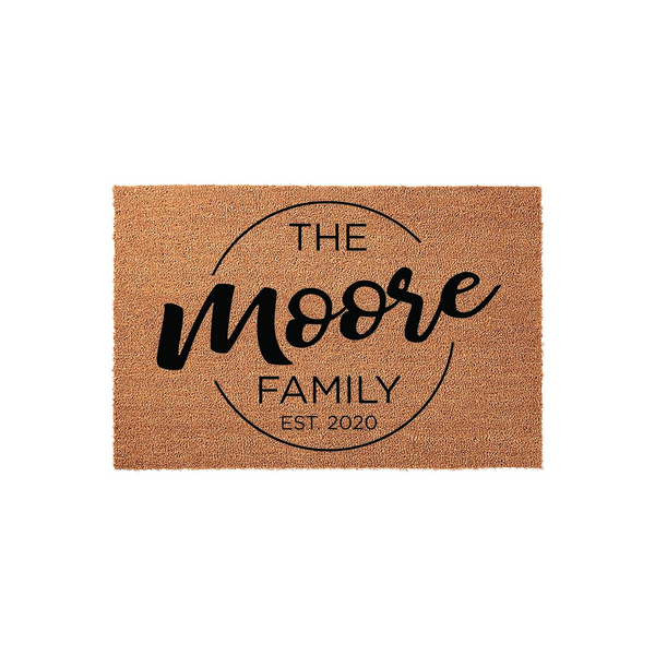 Personalized family name coir doormat featuring a circular design with custom text and an established year, presented on a clean white background to showcase the natural fiber texture and bold black lettering for a modern home