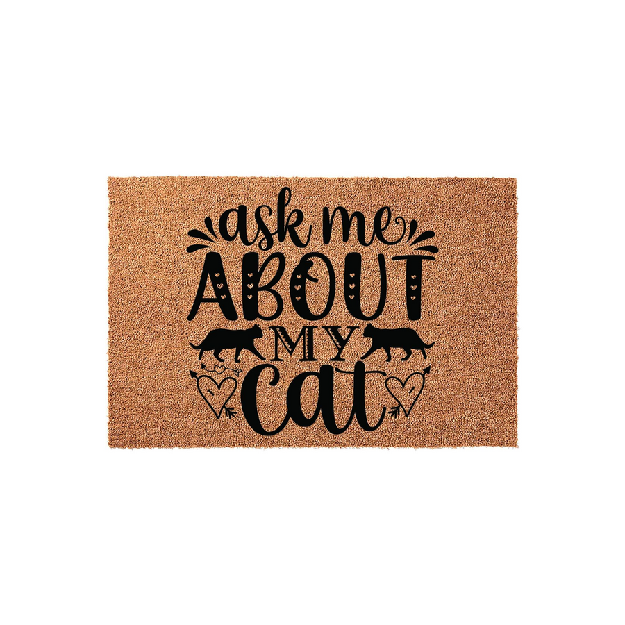 Ask Me About My Cat coir doormat featuring black text and silhouettes of two cats, accented with decorative hearts and arrows on a natural brown fiber background, perfect for a pet lover's front porch entrance or home entryway