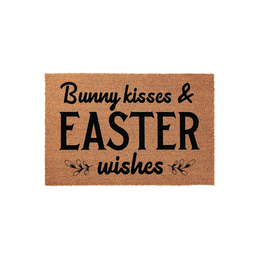 Bunny Kisses and Easter Wishes coir doormat featuring a natural brown fiber texture with bold black lettering and decorative floral accents, creating a festive spring entryway decor piece for your home during the holiday season.