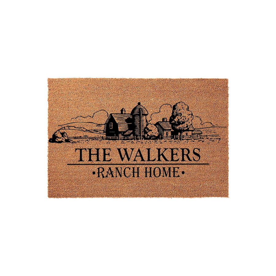 Personalized Farmhouse Coir Doormat featuring a black ink illustration of a rustic barn and silo landscape, with custom family name text and ranch home lettering printed on a natural brown coconut fiber mat against a white