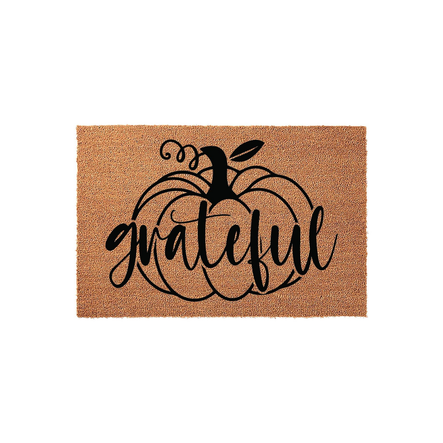 Grateful pumpkin coir doormat featuring a natural tan fiber texture and a bold black graphic of a large pumpkin with the word grateful written in elegant cursive script across the center, perfect for fall porch decor and seasonal