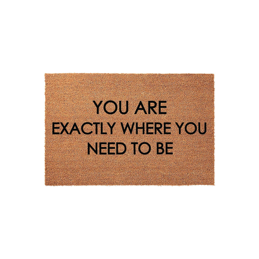 Inspirational Quote Coir Doormat featuring the text You Are Exactly Where You Need To Be printed in bold black lettering on a natural brown fiber mat, providing a welcoming and positive entryway decor piece for your front porch