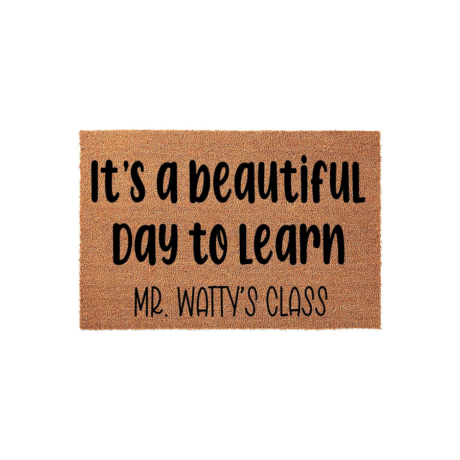 Personalized Teacher Classroom Doormat featuring the phrase It's a beautiful day to learn in bold black lettering on a natural coir fiber mat, customized with a teacher's name to welcome students into the classroom for the school