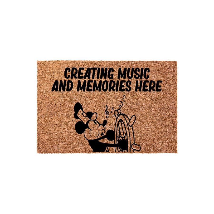 Creating Music and Memories Here coir doormat features a black silhouette of a classic cartoon mouse steering a ship wheel with musical notes floating above, set against a natural tan textured fiber background for a fun entryway
