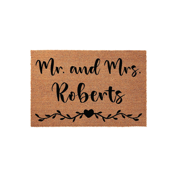 Personalized Mr. and Mrs. coir doormat featuring a natural brown fiber texture with black script lettering and a decorative vine and heart design, making a charming addition to any front porch or entryway for a newly married