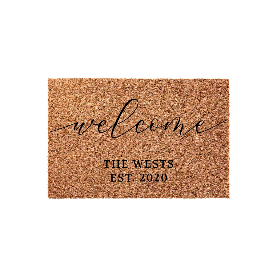 Personalized coir welcome doormat featuring elegant black script lettering and custom family name text with an established date, displayed against a clean white background for a classic and inviting front porch entryway aesthetic.