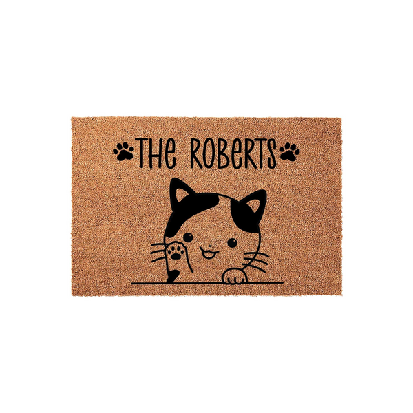 Personalized cat welcome doormat featuring a cute illustrated calico cat peeking over a line with black paw prints and custom family name text on a natural coir fiber background, creating a charming entryway decor piece for cat