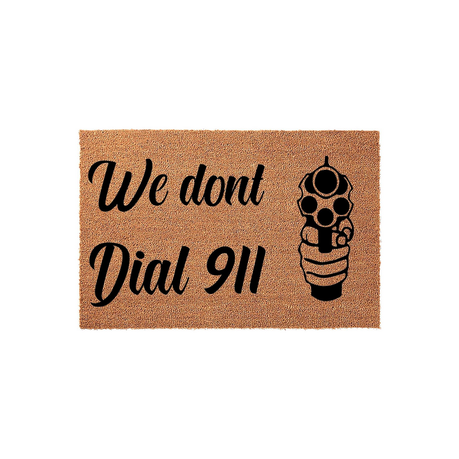 We dont dial 911 doormat featuring a natural coir texture with bold black text and a graphic illustration of a hand holding a revolver, creating a rustic and humorous entryway decor piece for a home with a gun-themed sense of
