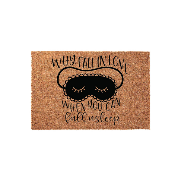 Funny Why Fall In Love When You Can Fall Asleep coir doormat featuring a black sleep mask illustration with closed eyes and eyelashes, printed on a natural brown textured coconut fiber mat against a clean white studio background.