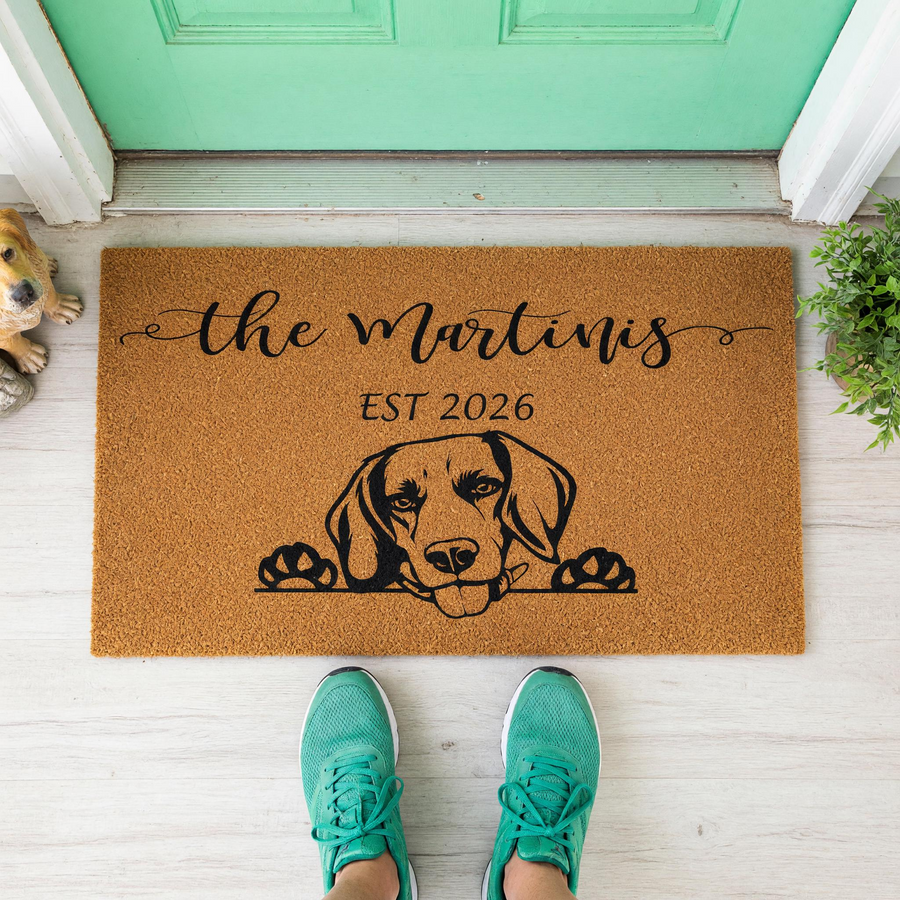 Personalized Beagle dog doormat featuring a custom family name and established year, displayed on a front porch with a natural coir texture and a black ink illustration of a curious dog peeking over the edge of the mat for a