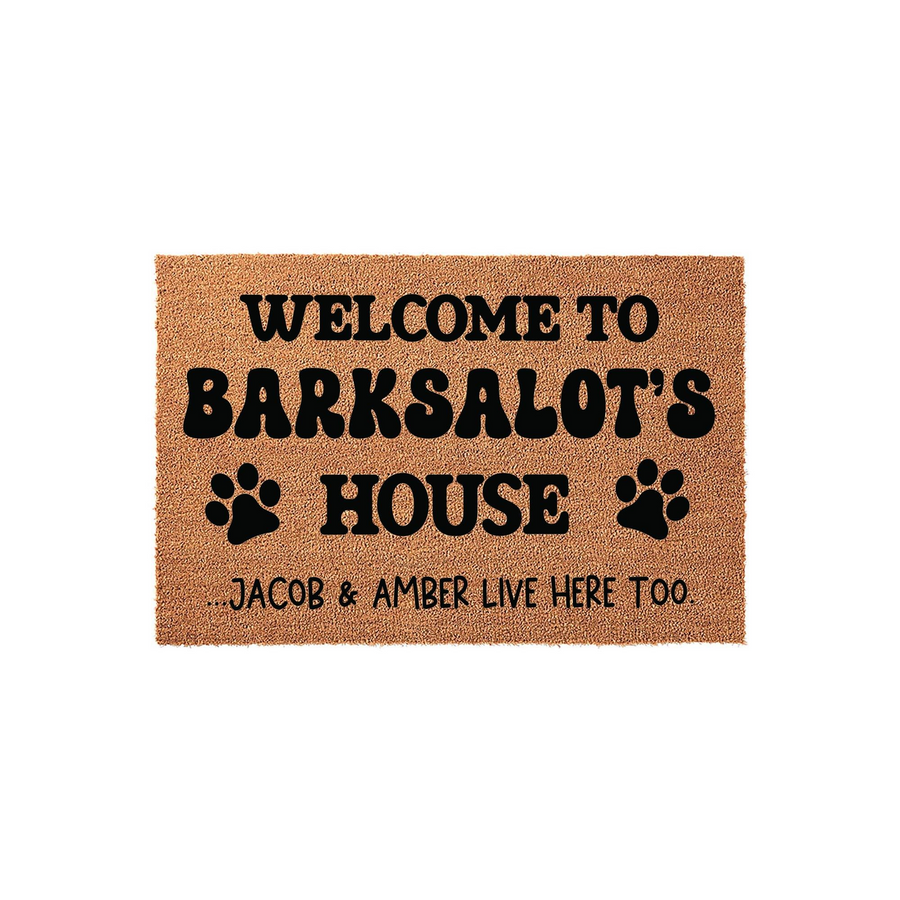 Personalized Dog Welcome Doormat featuring a natural coir texture with bold black text that reads Welcome to Barksalot's House, accented by two paw prints and a playful note about the humans who live there too on a clean white