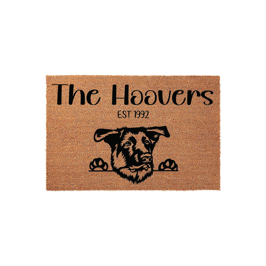 Personalized German Shepherd doormat featuring a natural coir texture with a black printed illustration of a dog peeking over the edge, customized with a family name and established year on a clean white studio background.