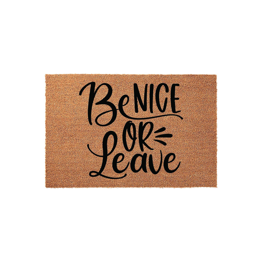 Be Nice Or Leave coir doormat featuring bold black hand-lettered typography centered on a natural brown fiber mat, creating a funny and welcoming front porch entrance decor piece for your home or apartment entryway.