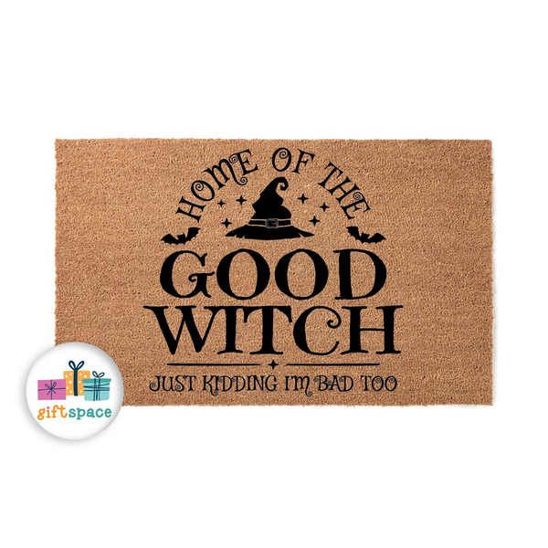 Funny Halloween doormat featuring a natural coir texture with black text that reads Home of the Good Witch, Just Kidding I am Bad Too, accented by a witch hat and bat silhouettes for a festive seasonal entryway decor piece.
