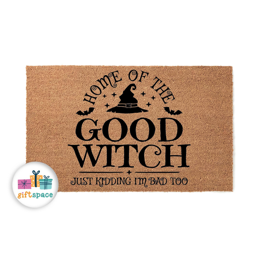 Funny Halloween doormat featuring a natural coir texture with black text that reads Home of the Good Witch, Just Kidding I am Bad Too, accented by a witch hat and bat silhouettes for a festive seasonal entryway decor piece.