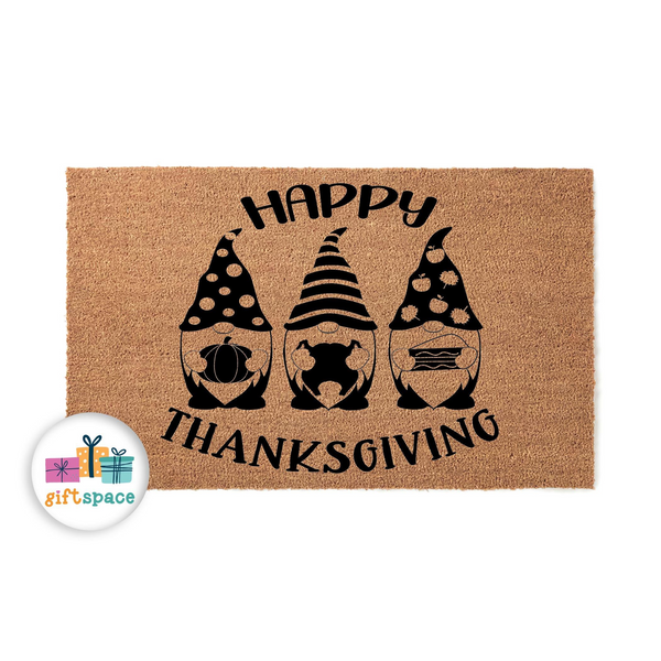 Happy Thanksgiving coir doormat featuring three cute gnomes holding a pumpkin, a turkey, and a pie, printed in black ink on a natural brown fiber mat to add a festive seasonal touch to your front porch entryway decor for the fall